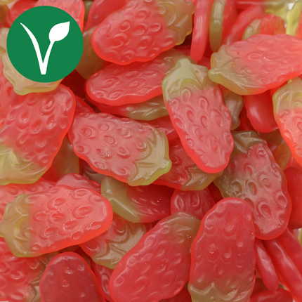 Vegan strawberry-shaped gummy candies in red and green colors, close-up view