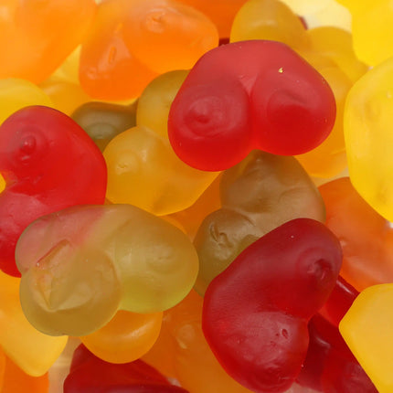 Colorful gummy candy shaped like hearts in red, yellow, and orange shades.