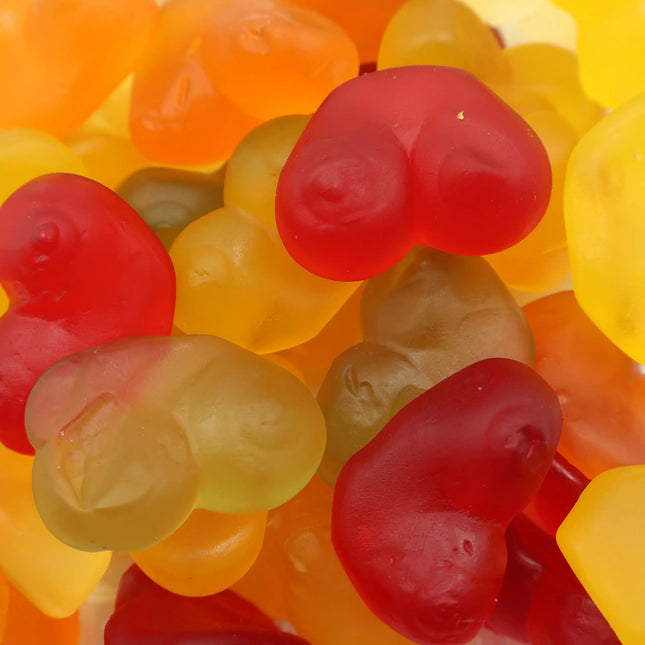 Colorful gummy candy shaped like hearts in red, yellow, and orange shades.